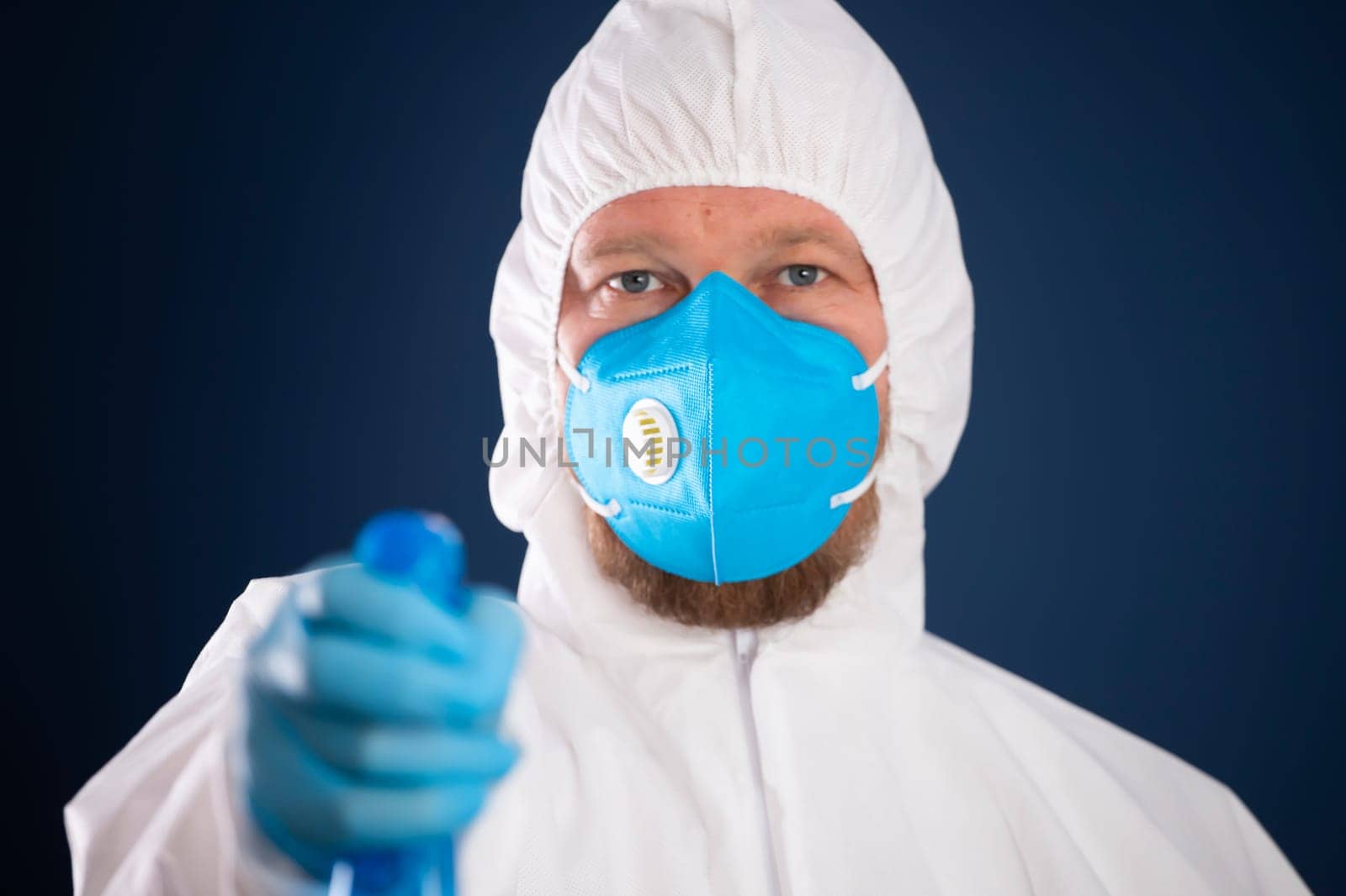 Conavirus pandemic. Man in full protected suit with disinfectant for prevention and control of epidemic.