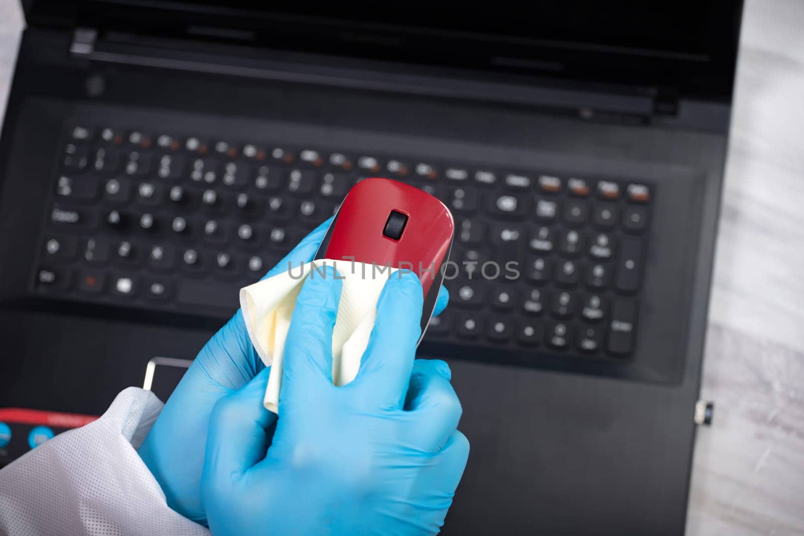 Office sanitizing wiping mouse with disinfectant. Coronavirus COVID-19 sanitize cleaning, disinfection of work desk.