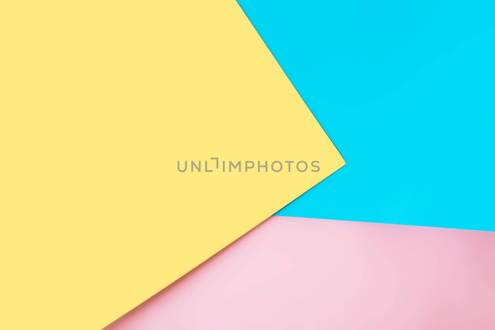 Background with multicolored sheets of paper placed geometrically randomly. Yellow, pink and blue paper sheets. High quality photo
