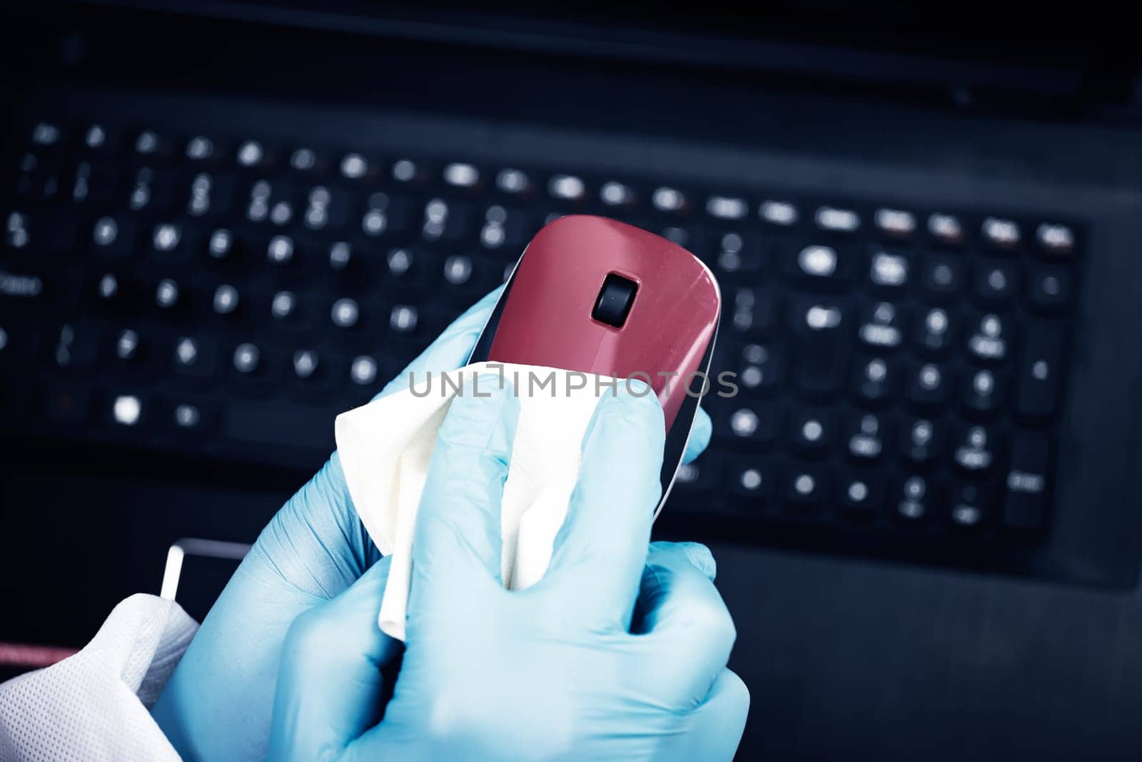 Office sanitizing wiping mouse with disinfectant. Coronavirus COVID-19 sanitize cleaning, disinfection of work desk.