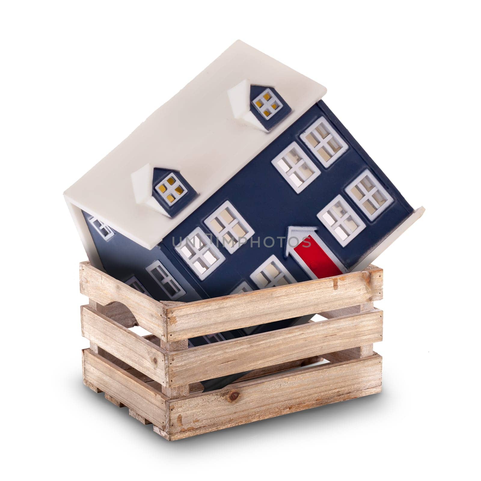 Moving house or storage concept with a little home in a crate or box isolated on a white background