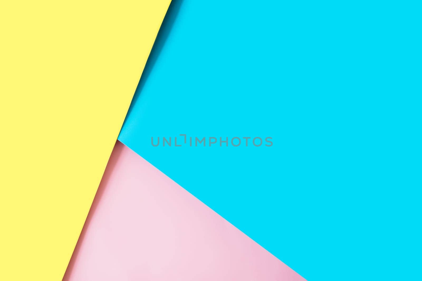 Background with multicolored sheets of paper placed geometrically randomly. Yellow, pink and blue paper sheets. High quality photo