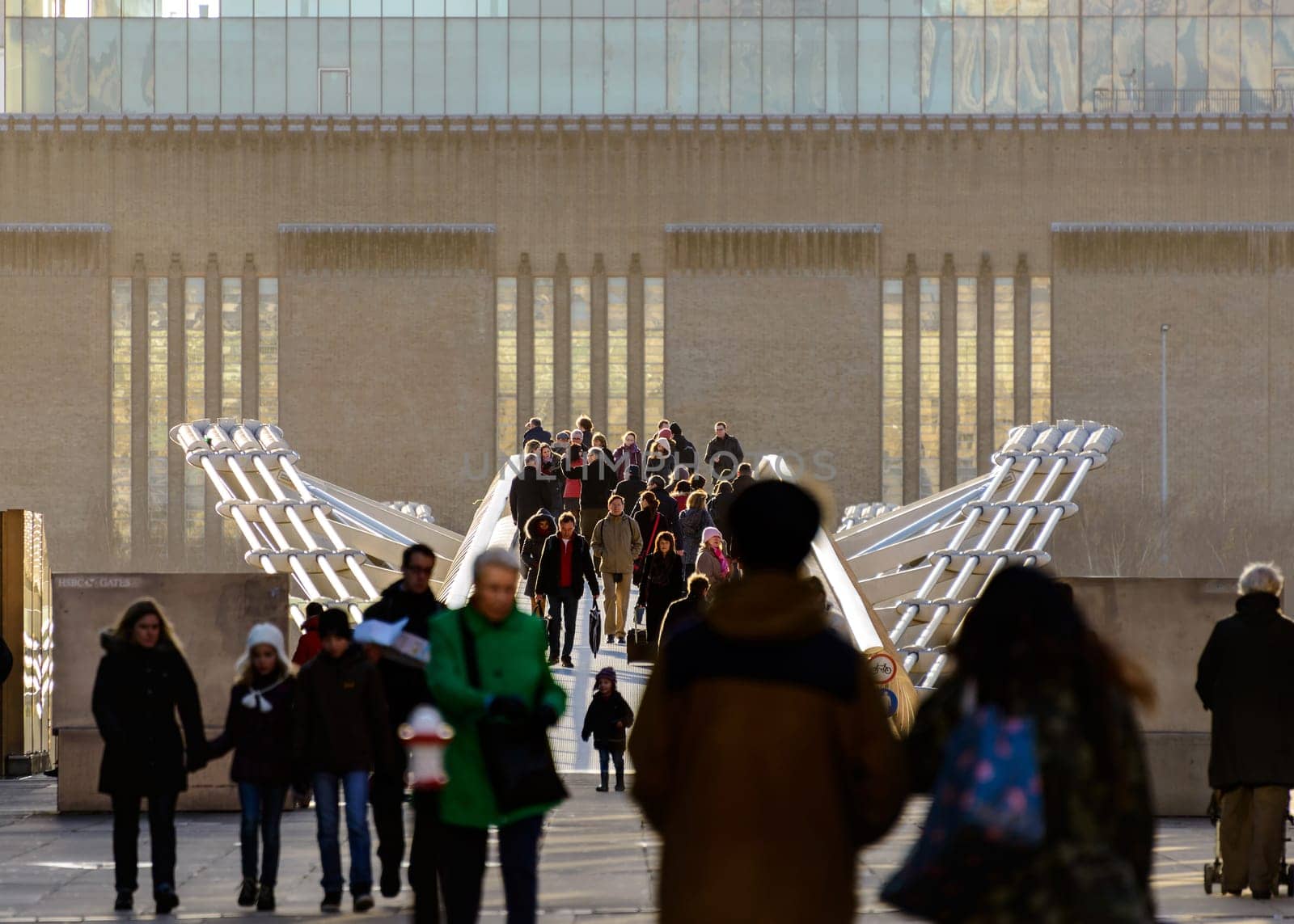 LONDON, UK - CIRCA JANUARY 2013: People on the Millennium Bridge. The Millennium Bridge is a steel suspension footbridge over the Thames River for pedestrians.