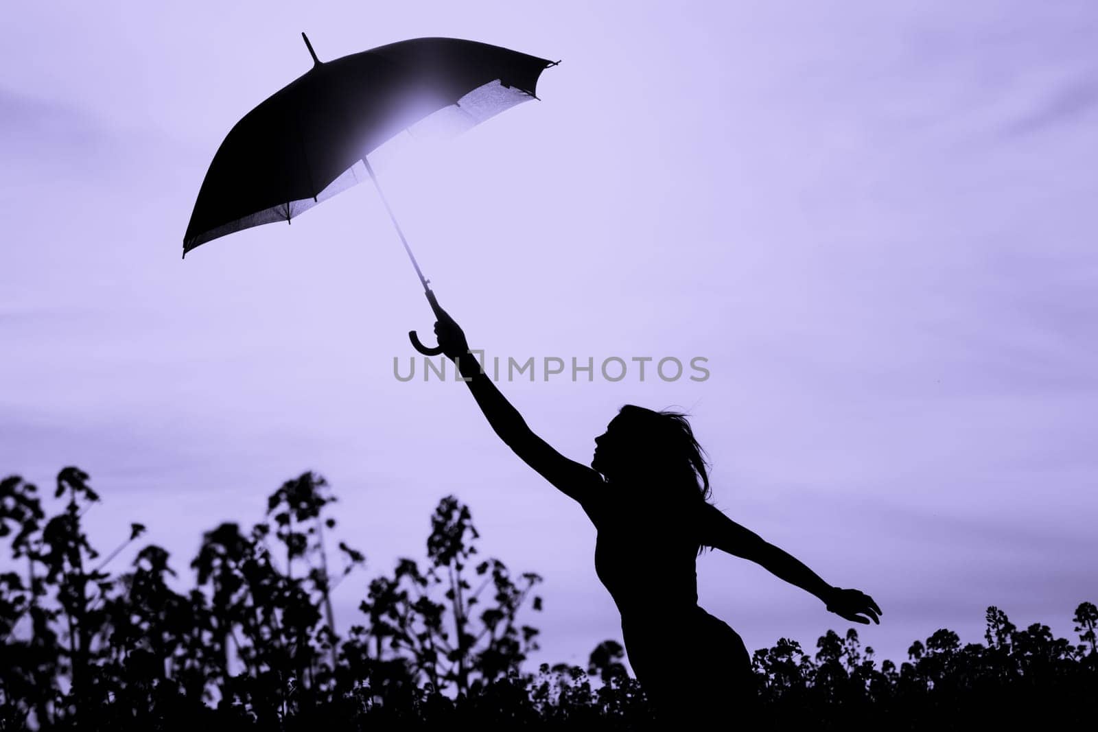 Nature girl at windy rainy day has adventure wanderlust. Wonderful scene of imagination power and departure to new horizons in youth.