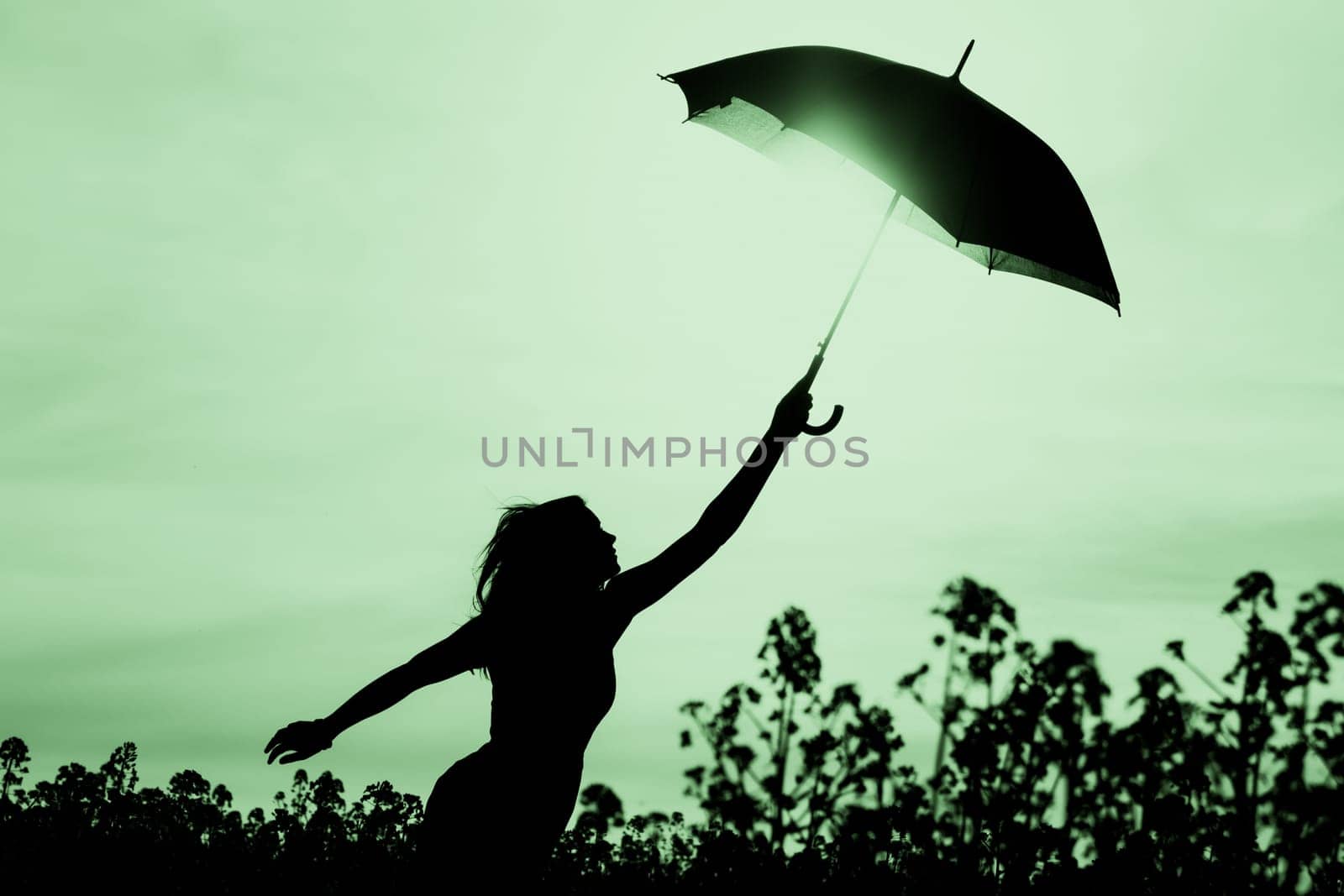 Nature girl at windy rainy day has adventure wanderlust. Wonderful scene of imagination power and departure to new horizons in youth.