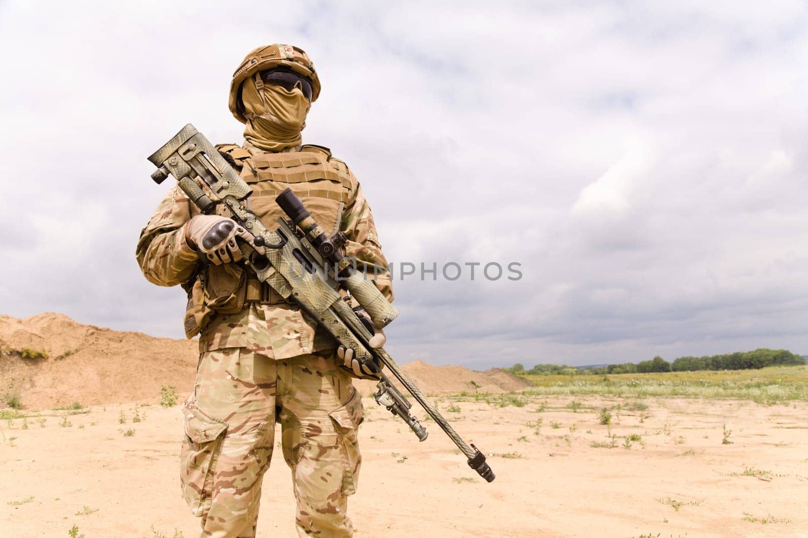 Equipped and armed special forces soldie in the desert, copy space fo text.