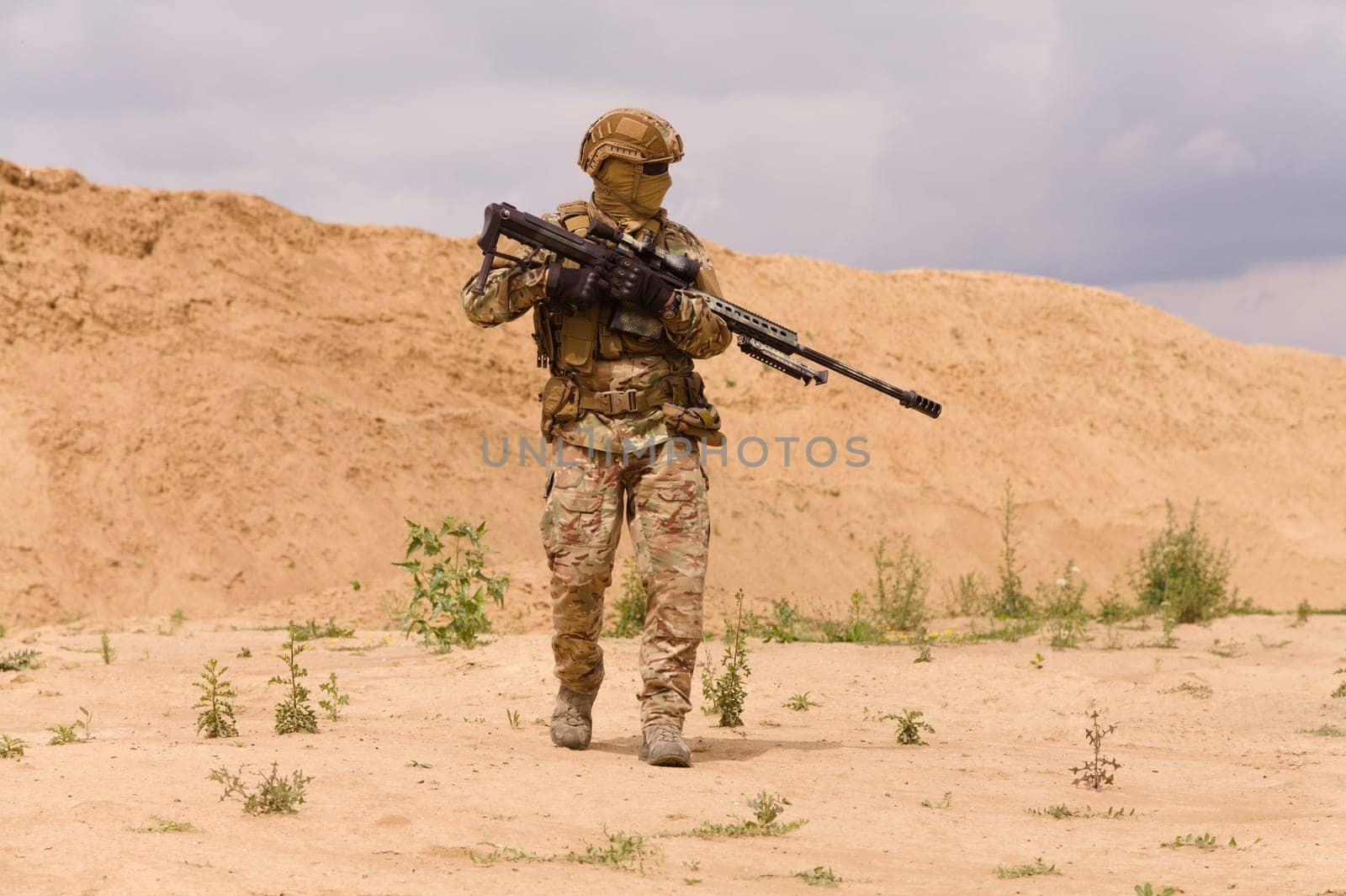 Equipped and armed special forces soldier with rifle in the desert during the military operation.