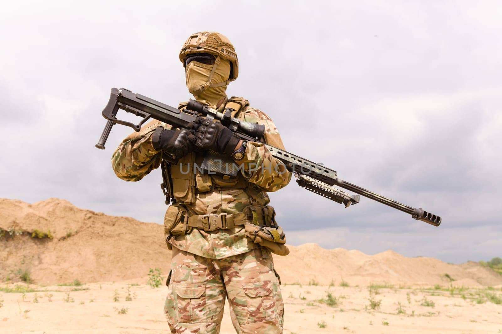 Soldier in camouflage holding sniper rifle close-up