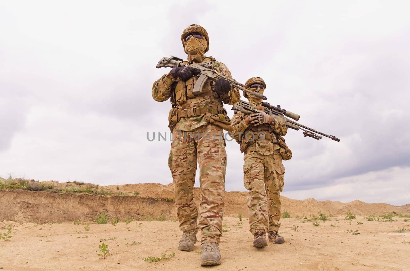 Equipped and armed special forces soldiers with rifles during military operation in the desert