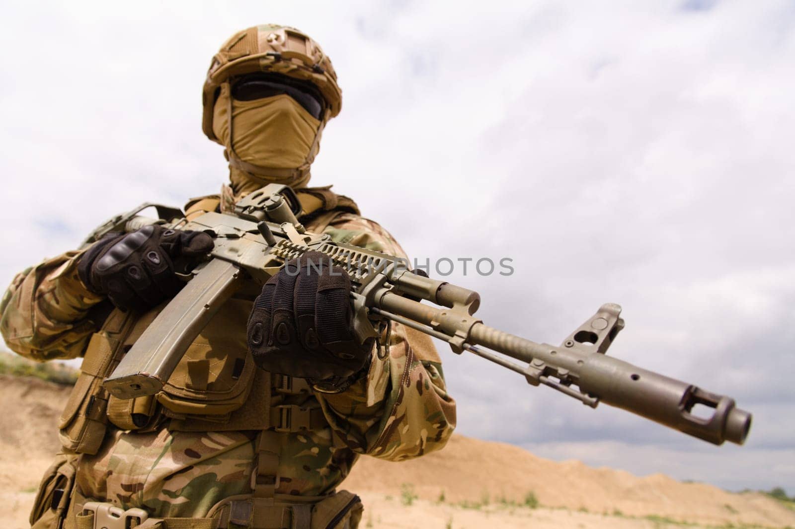 Army soldier holding rifle against sky background, copy space for text