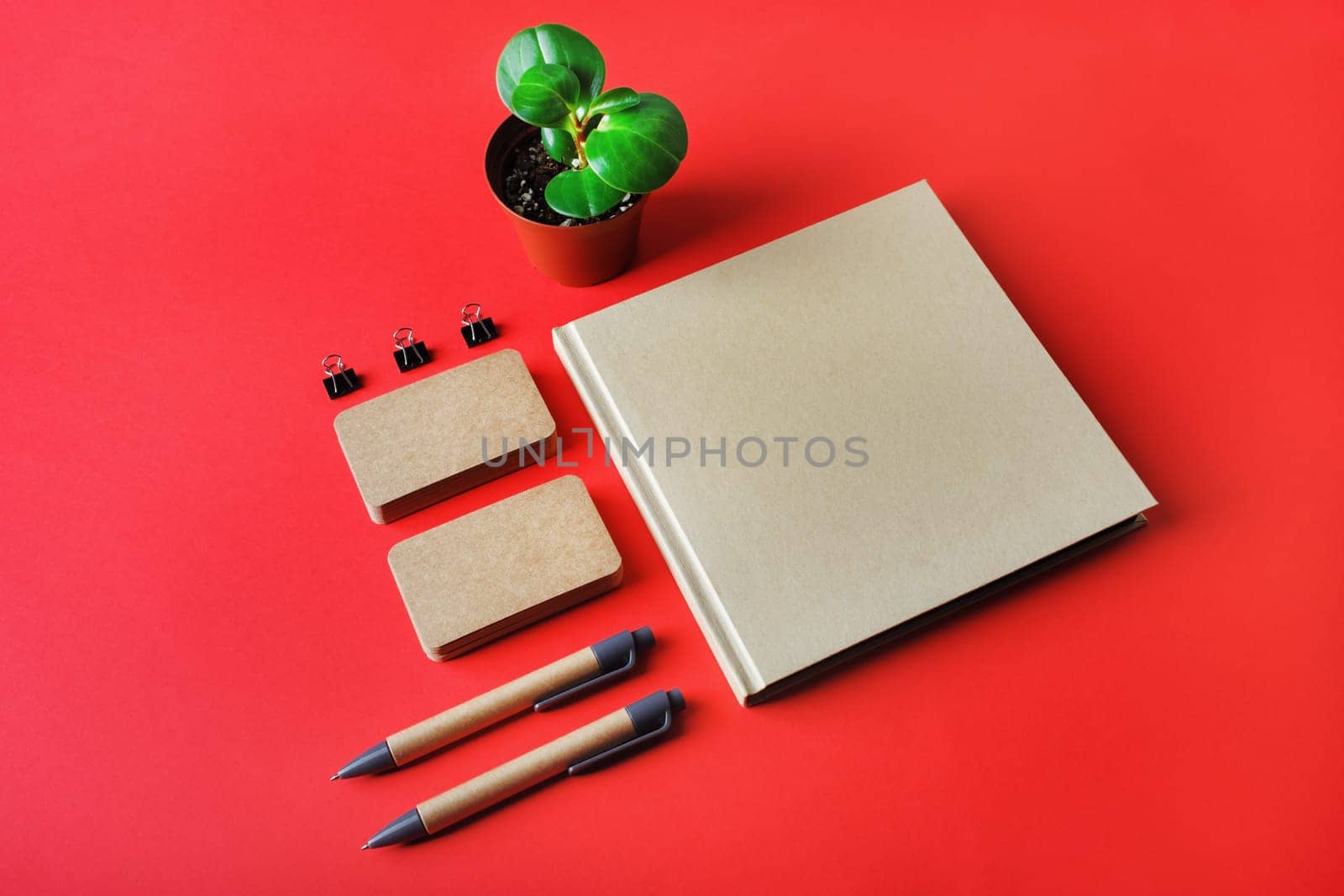 Photo of blank kraft stationery set on red paper background. Template for branding identity. Identity set mock-up.
