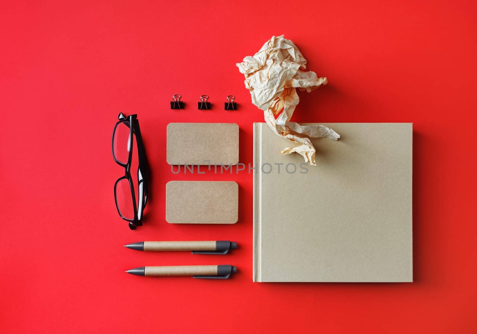 Blank corporate identity template on red paper background. Photo of blank kraft stationery set. Mockup for design presentations and portfolios. Flat lay.