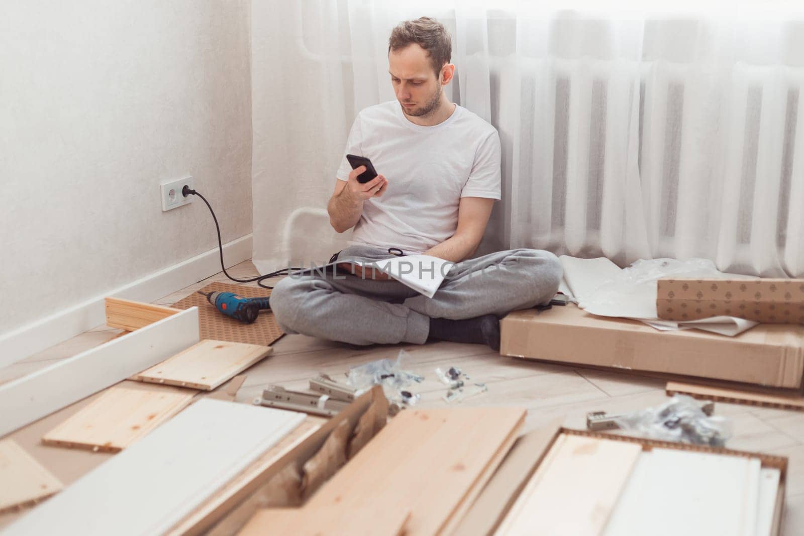 Man looking contacts of help center. Troubles with assembling new furniture, calling for a master