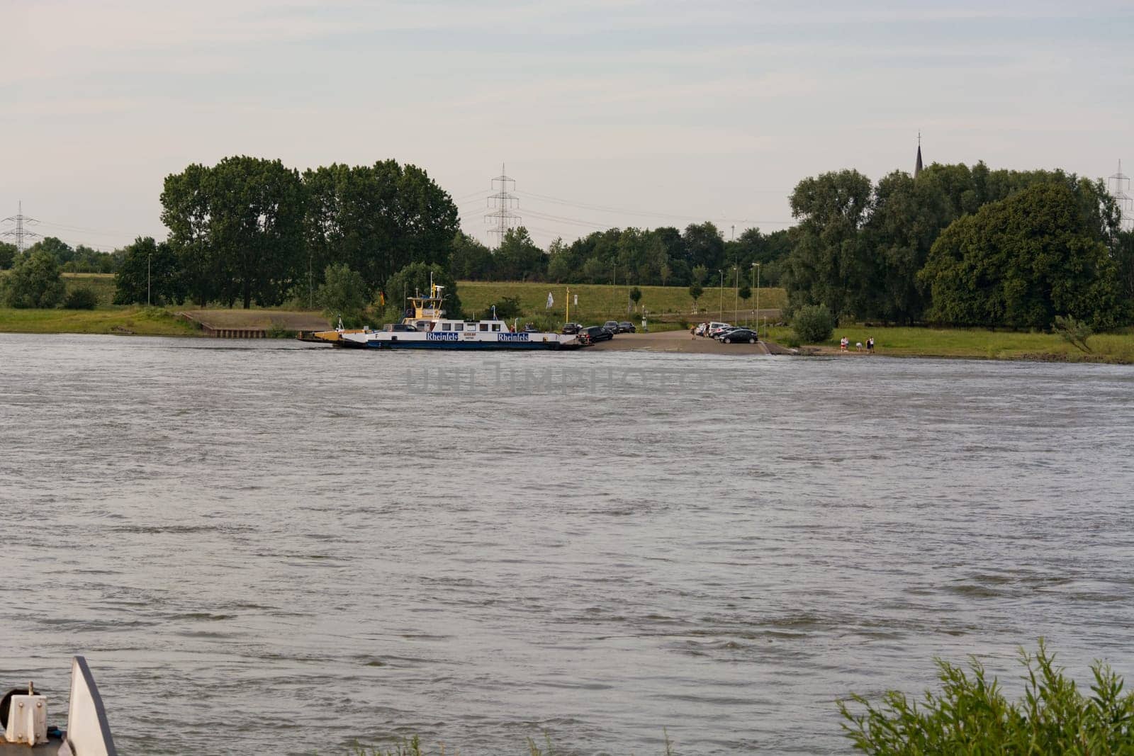 ORSOY, NRW, GERMANY - JUNE 23, 2019:  Ferry City Orsoy on the Rhine. The ferry connects Orsoy in NRW, the city of Duisburg Walsum. Some passengers on the ship