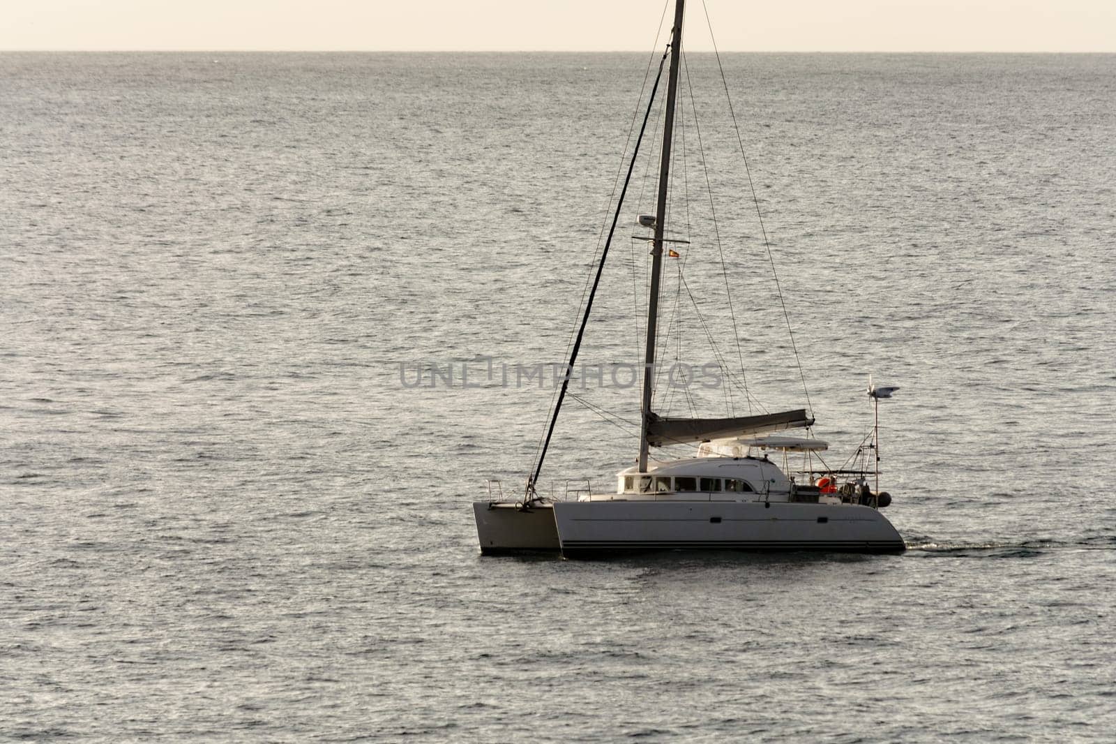 Yacht - catamaran in the tropical sea at sunset. Yachting / luxury sailing theme