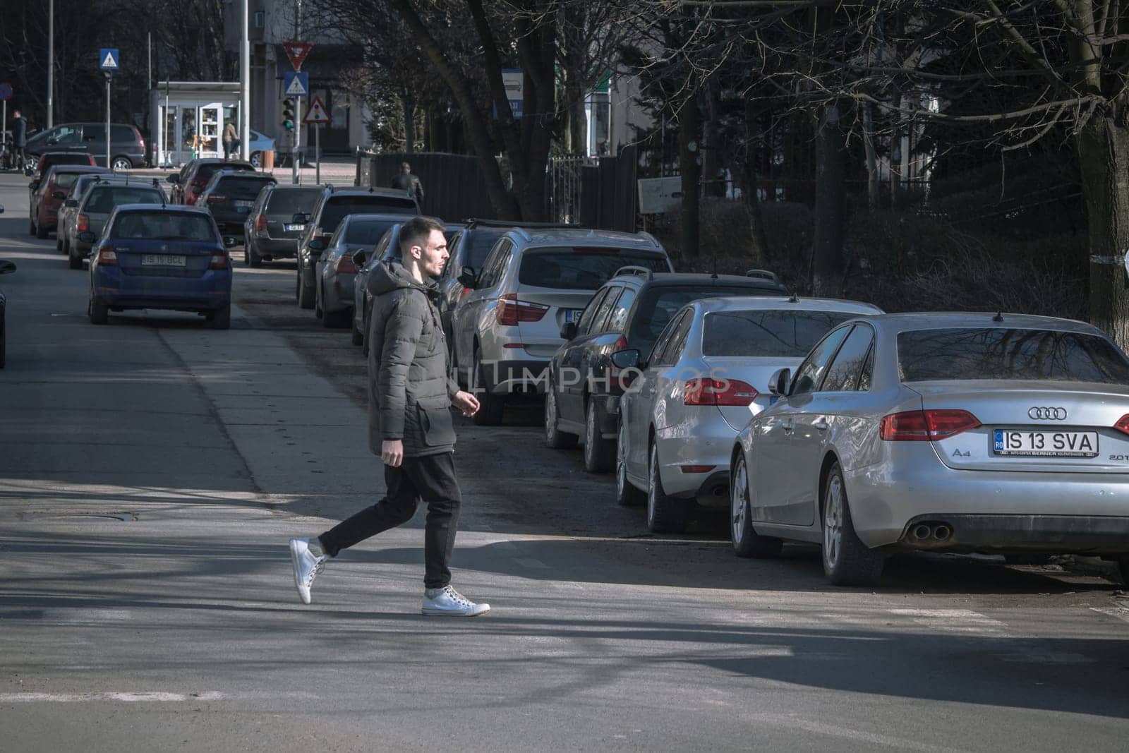 Iasi - Romania - 13th March 2021: Guy crossing the street
