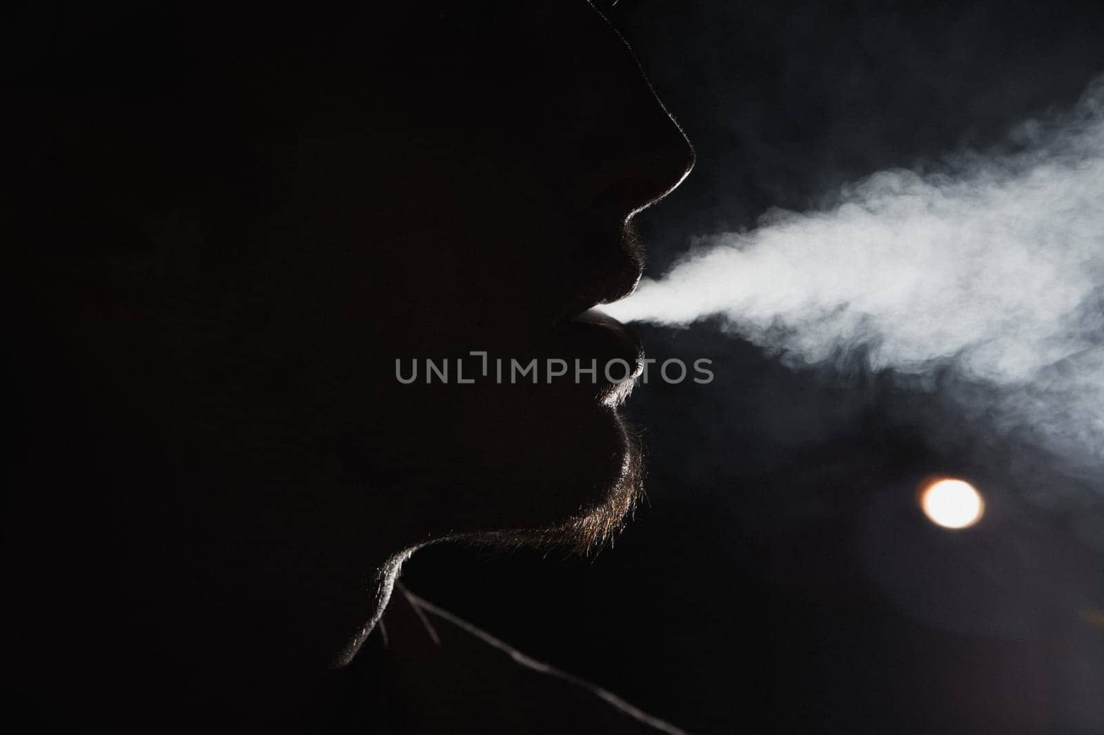 Close up portrait of young man smoking cigarette