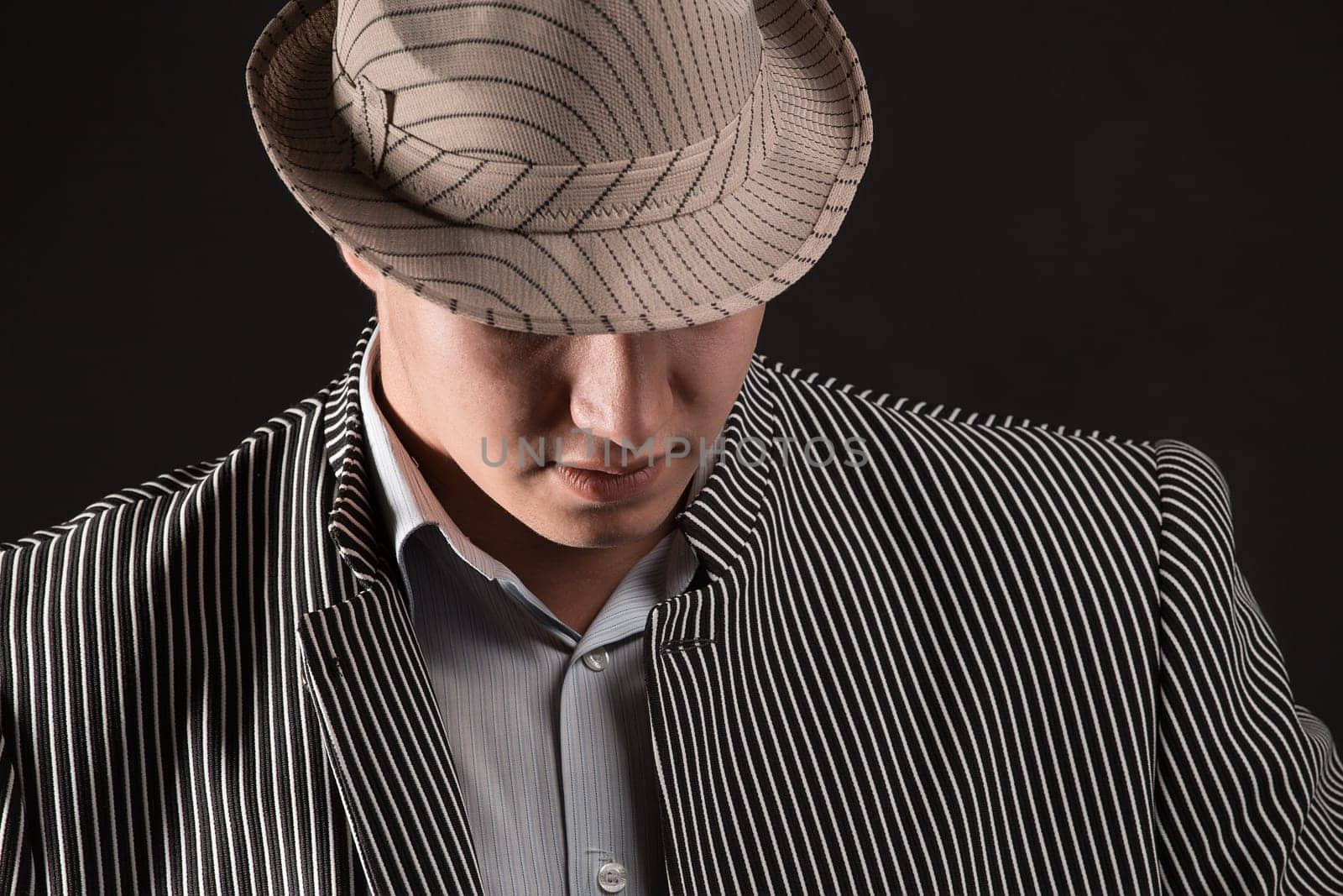 The man in style Chicago gangster on dark background