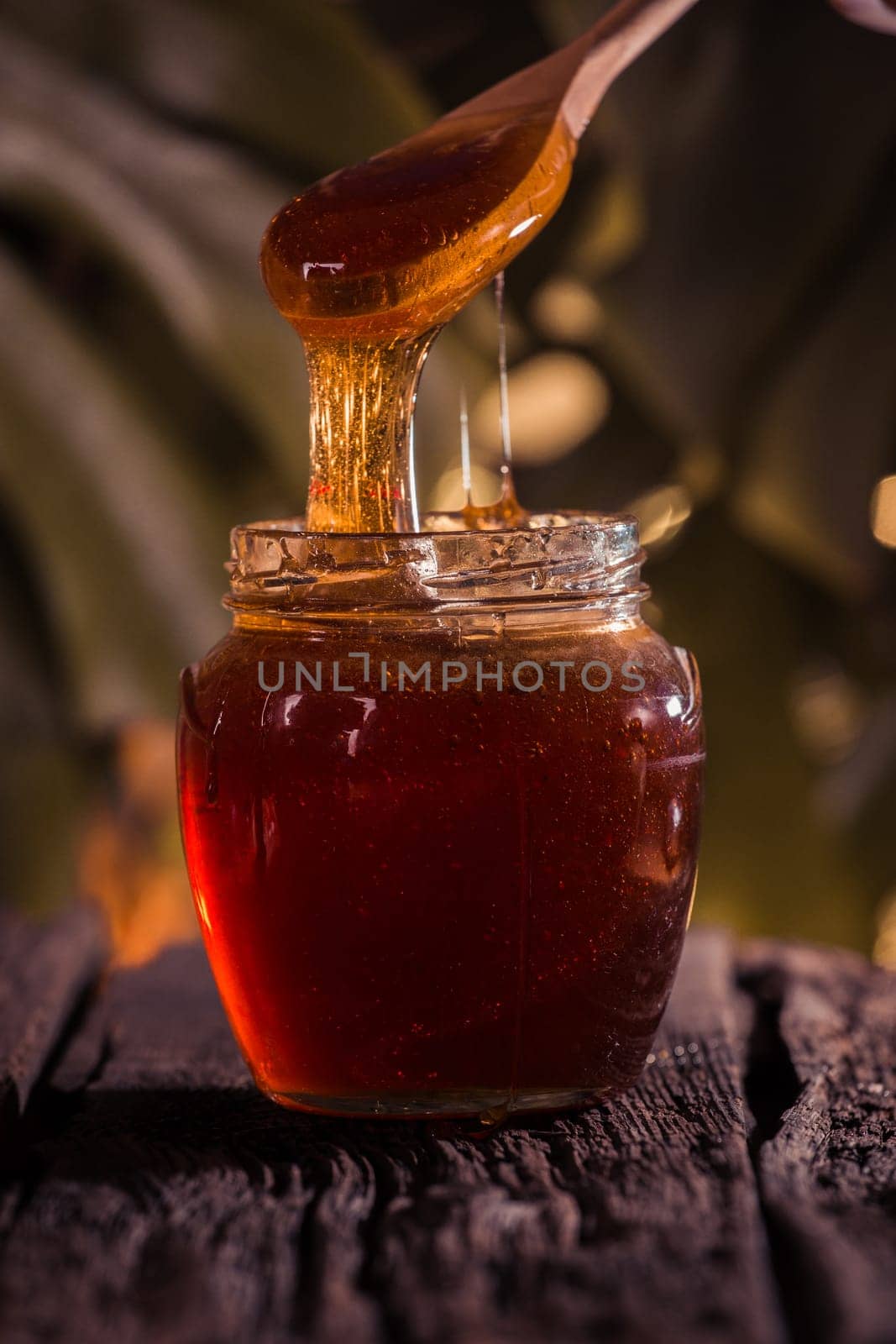 Honey drip in jar on the table