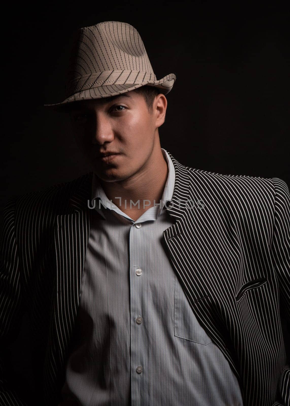 a man in a grey hat on black background