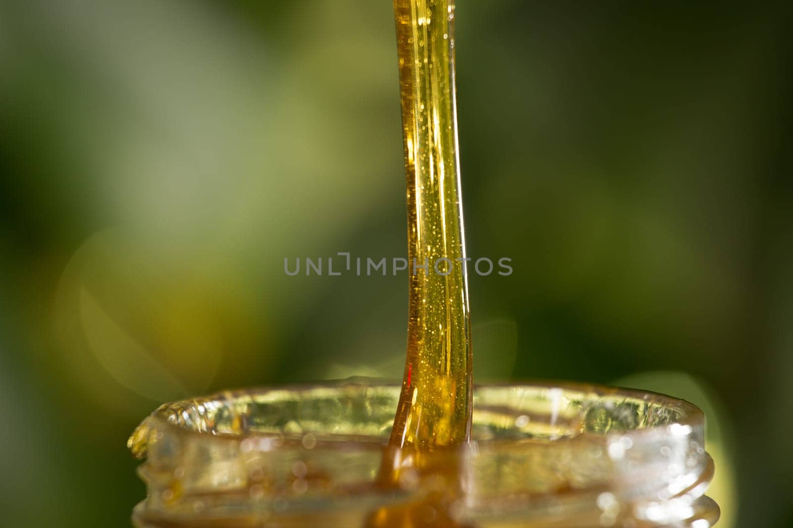 Close-up shot of flowing honey over yellow background