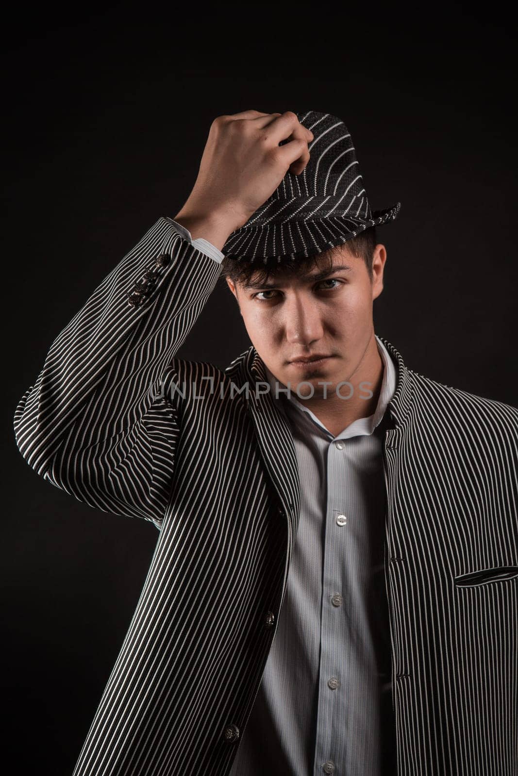a man in a grey hat on black background
