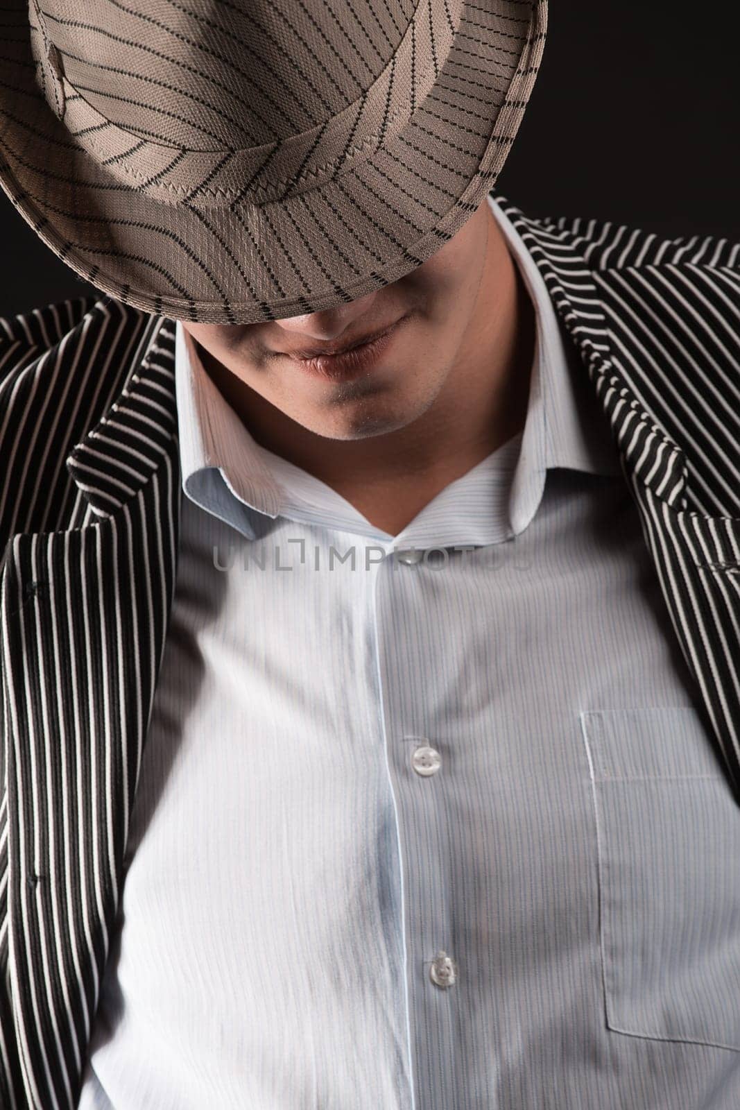 a man in a grey hat on black background