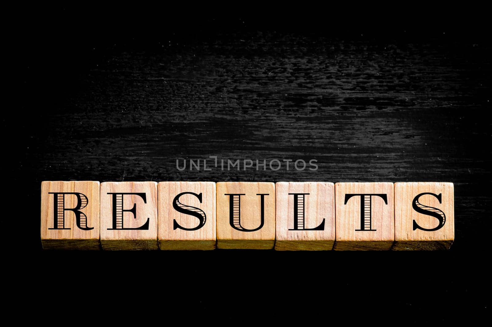 Word Results.Wooden small cubes with letters isolated on black background.Concept image.