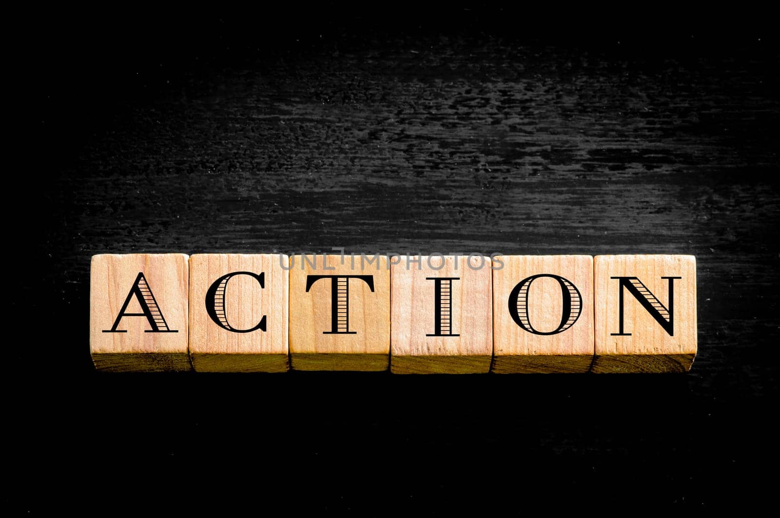 Word Action. Wooden small cubes with letters isolated on black background.Concept image.