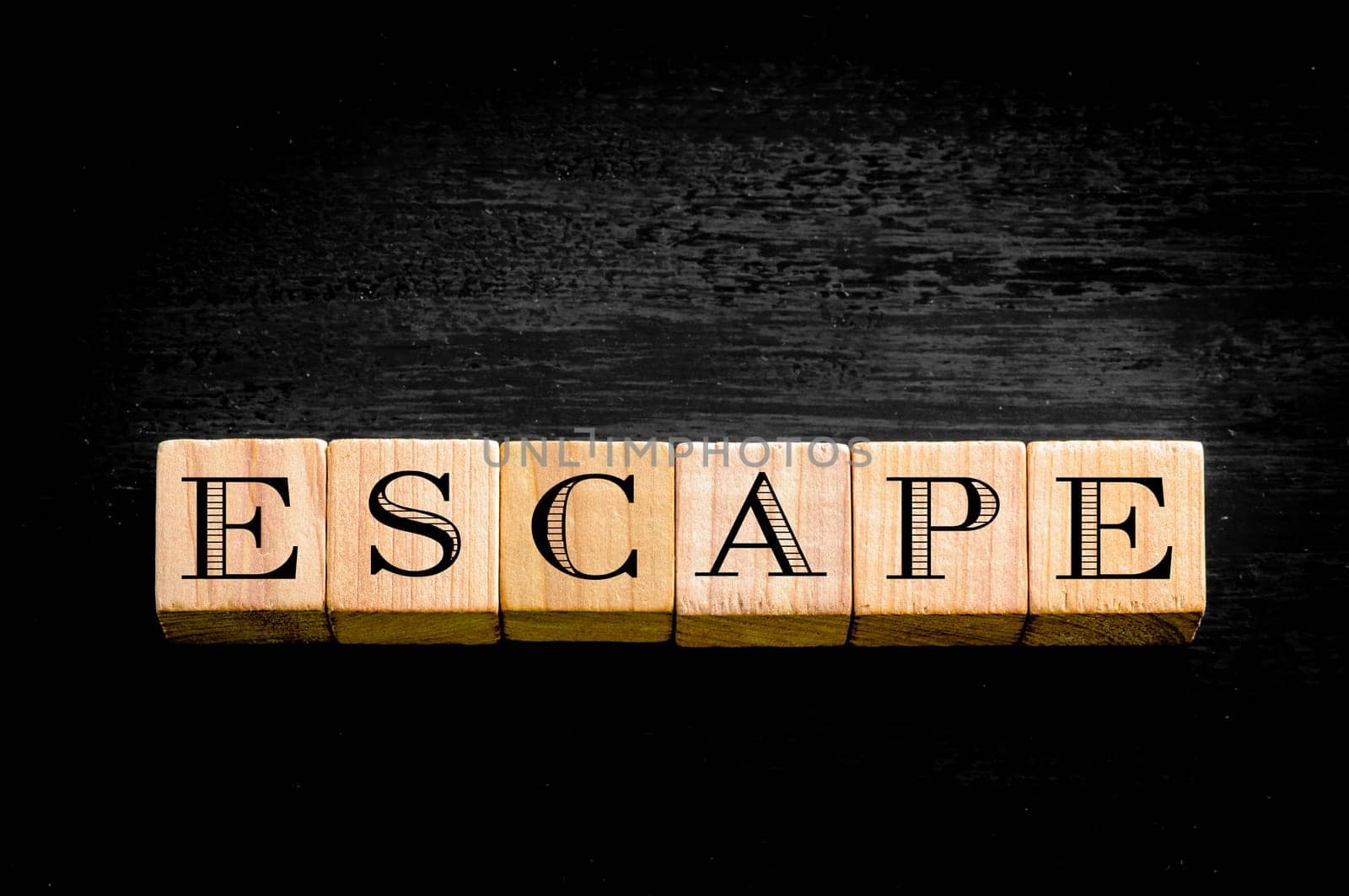 Word Escape. Wooden small cubes with letters isolated on black background.Concept image.