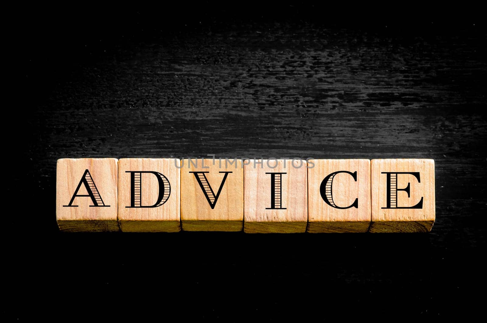 Word Advice. Wooden small cubes with letters isolated on black background.Concept image.