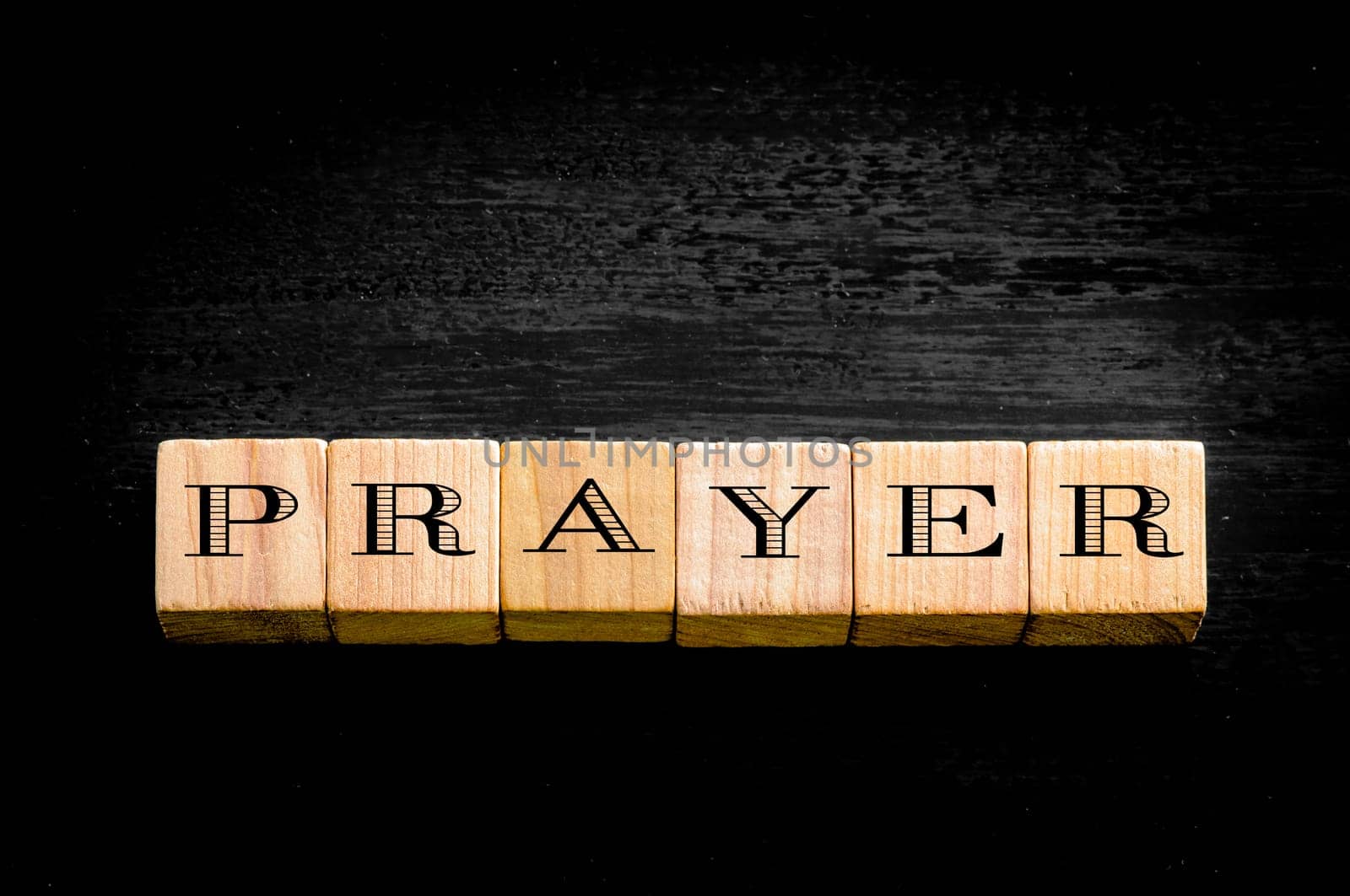 Word Prayer. Wooden small cubes with letters isolated on black background.Concept image.