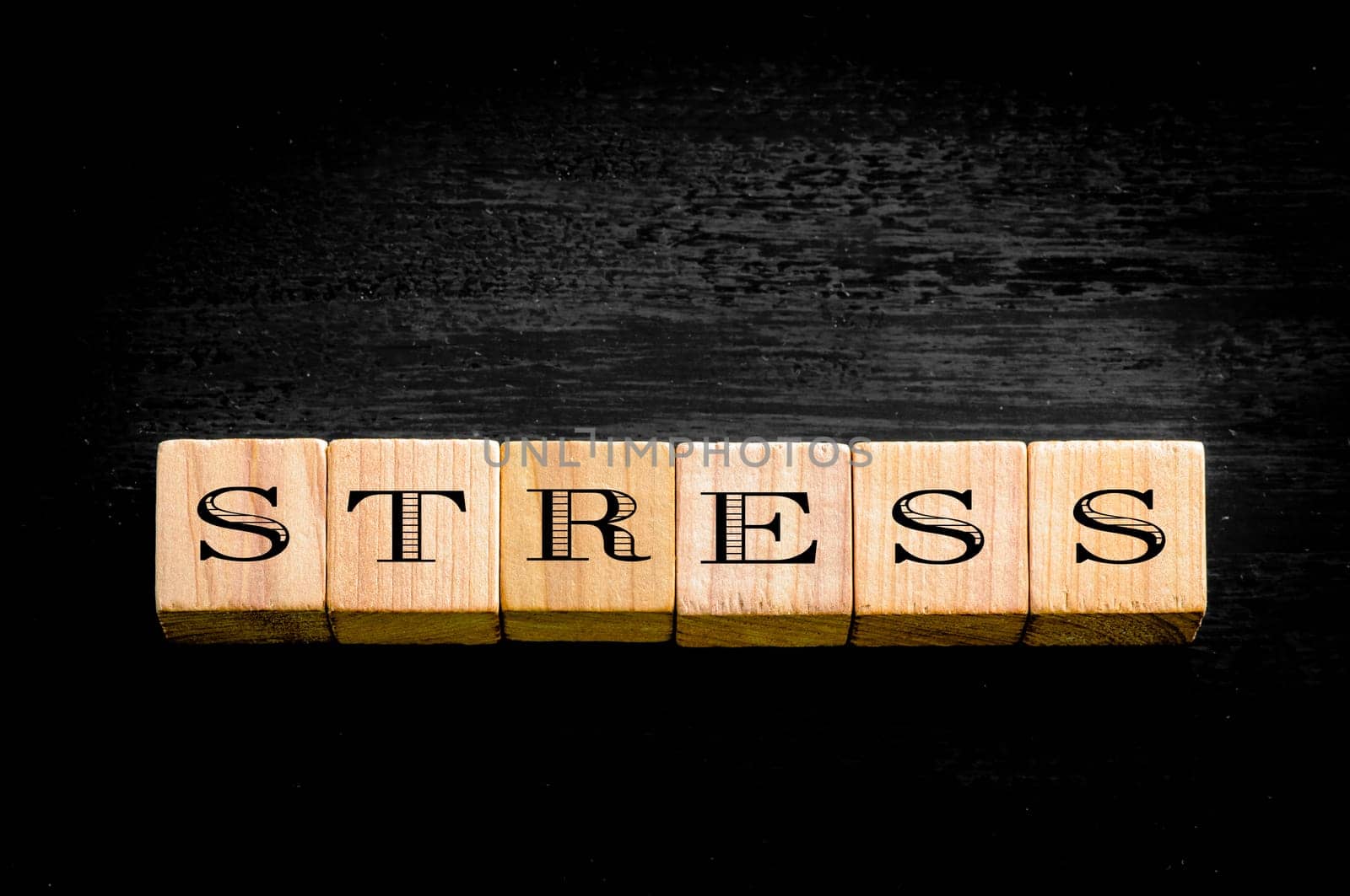 Word Stress. Wooden small cubes with letters isolated on black background.Concept image.