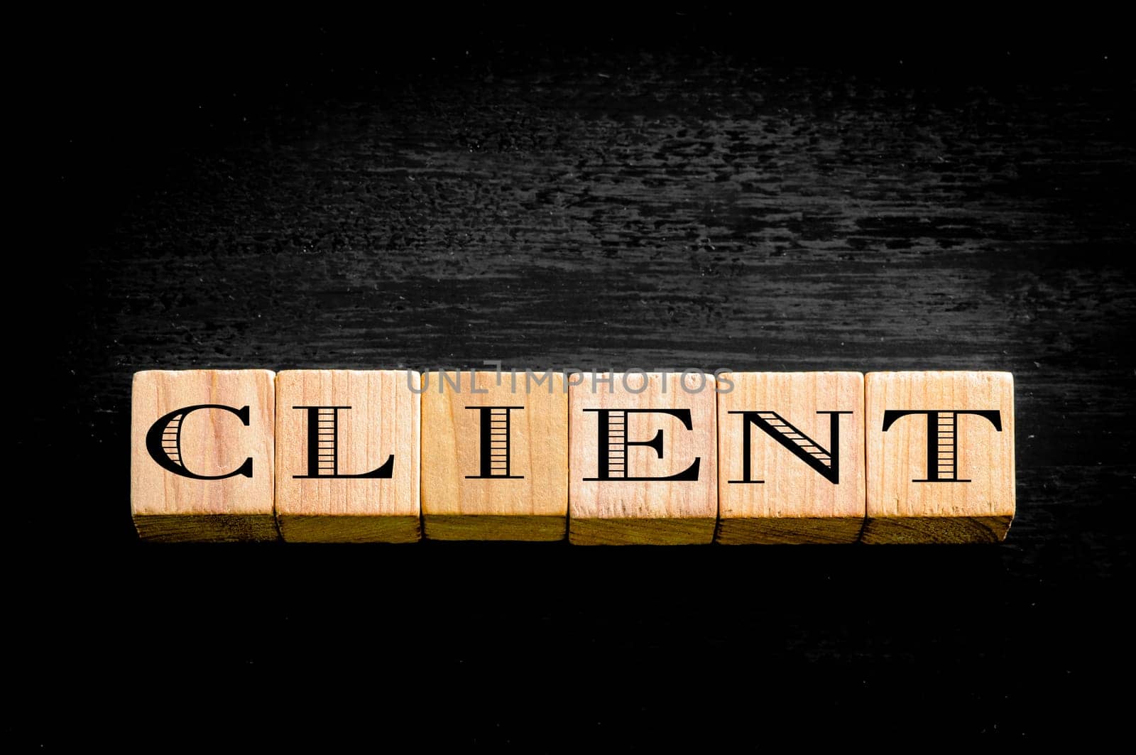 Word Client. Wooden small cubes with letters isolated on black background.Concept image.