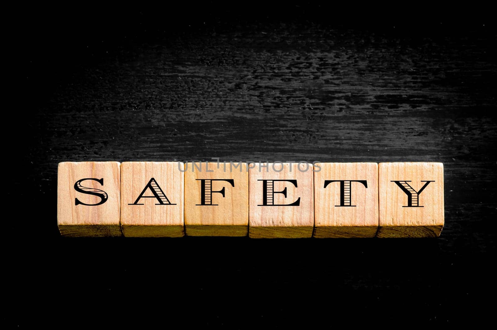 Word Safety. Wooden small cubes with letters isolated on black background.Concept image.