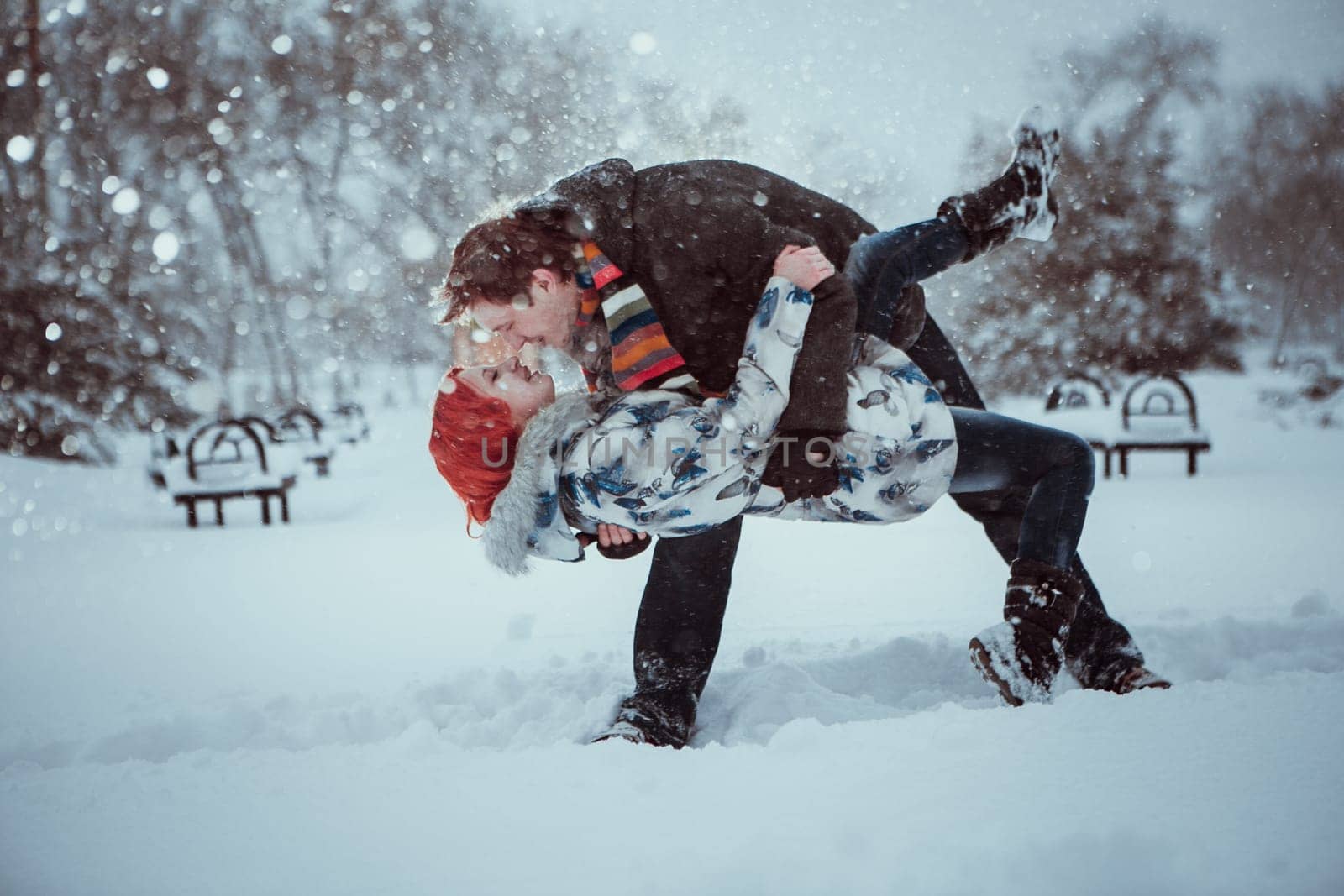 Happy Young Couple in Winter Park having fun.Family Outdoors. love kiss