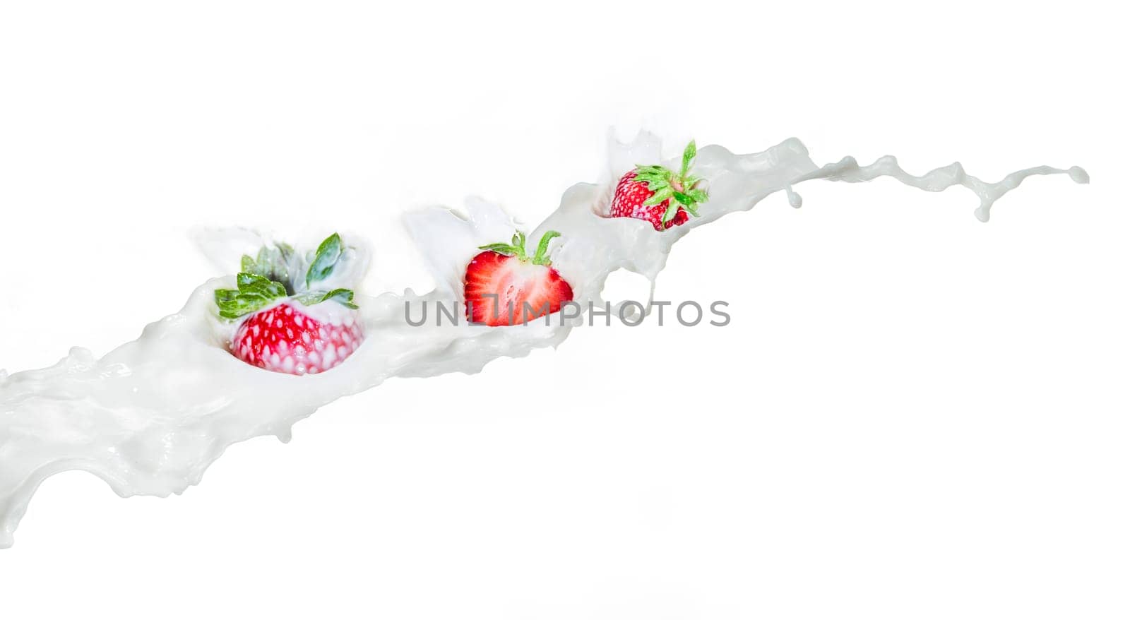 Strawberry falling into splashing milk. Isolated on white.