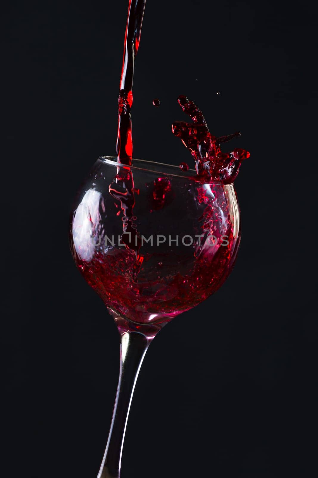 Red Wine Pouring into glass black isolated