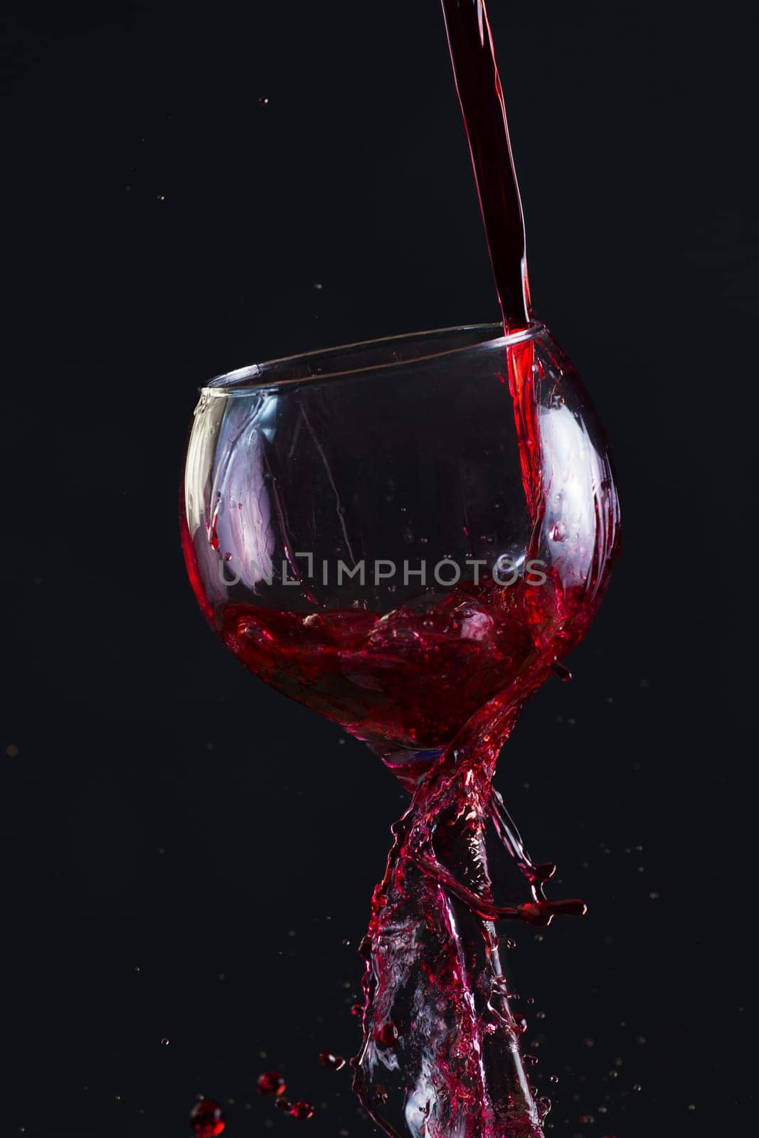 Red Wine Pouring into glass black isolated