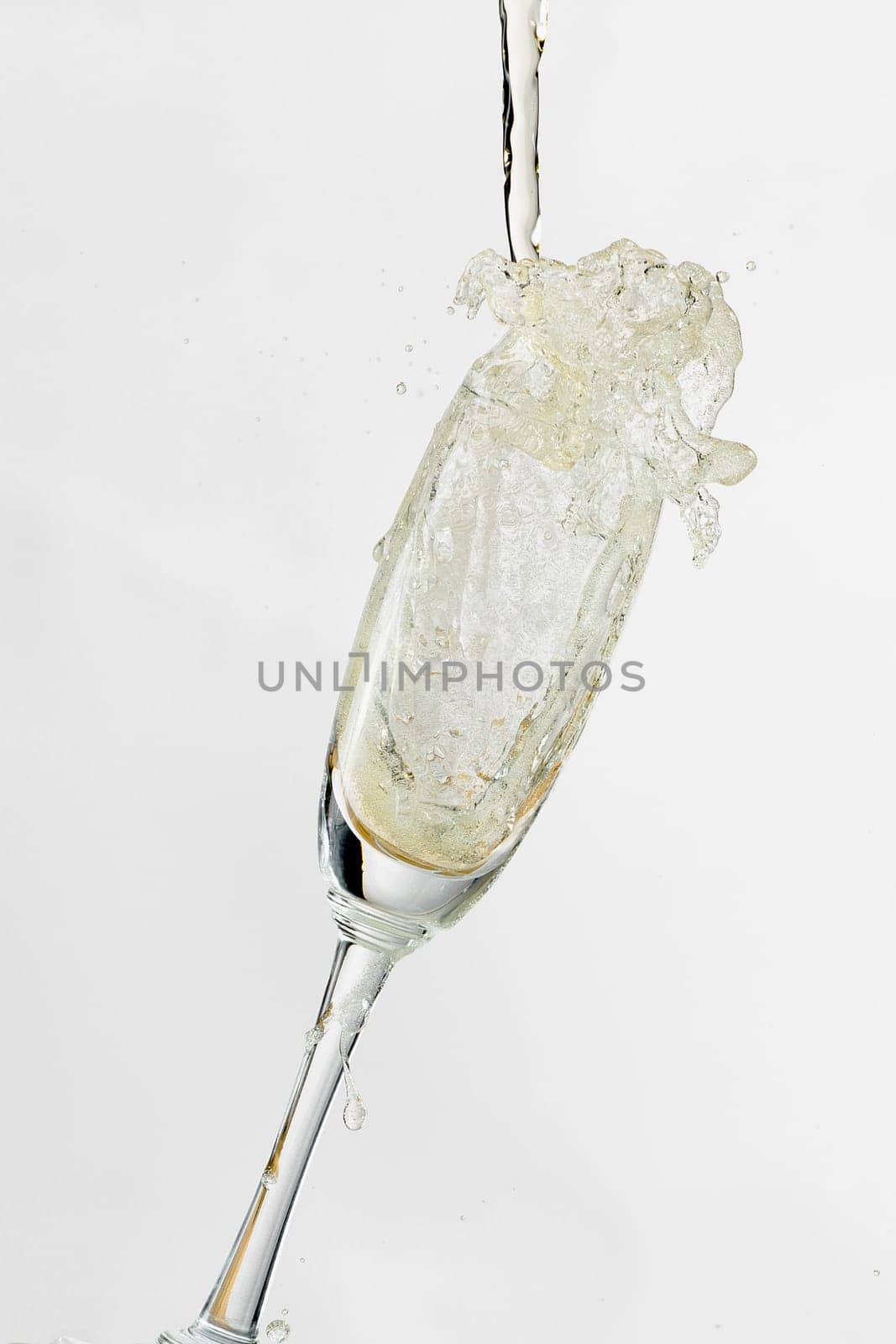 White wine splashing out of glass, isolated on white background