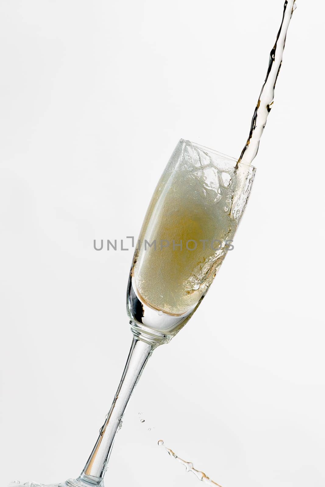 White wine splashing out of glass, isolated on white background