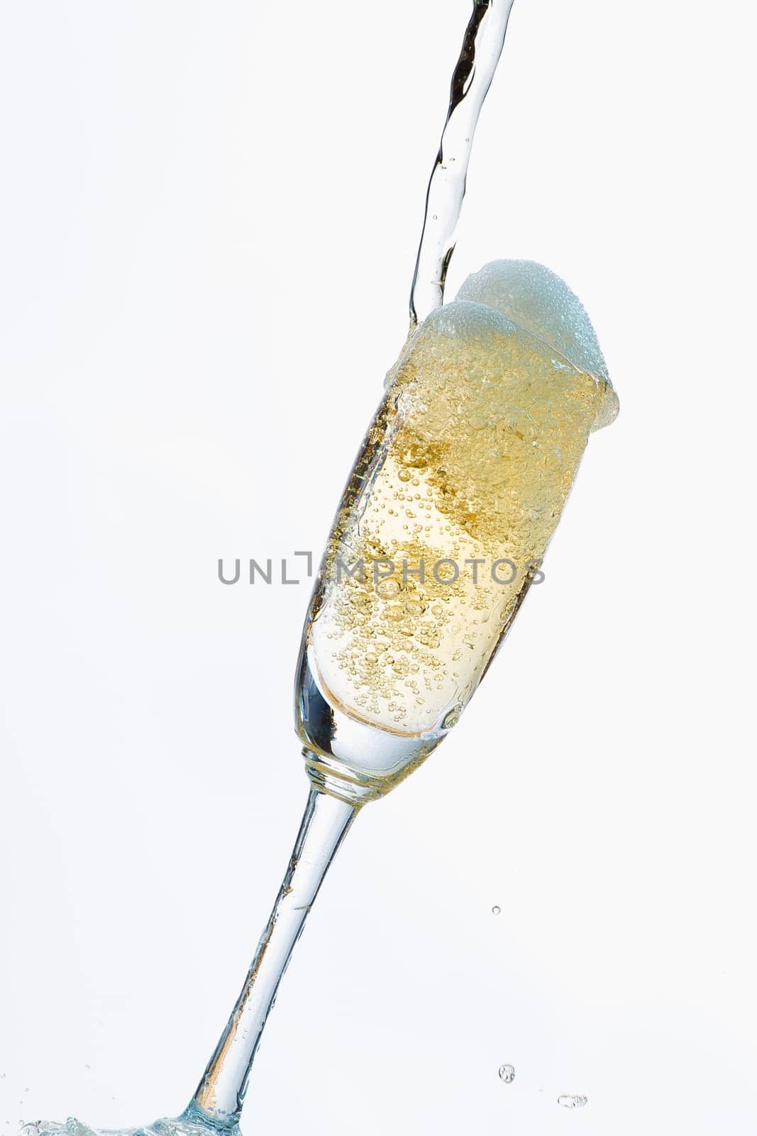 White wine splashing out of glass, isolated on white background