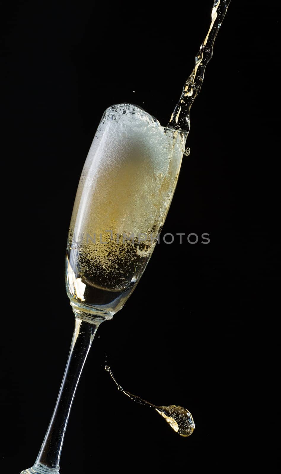 Glass of champagne with splash, isolated on black background