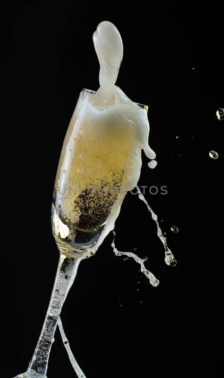 Glass of champagne with splash, isolated on black background