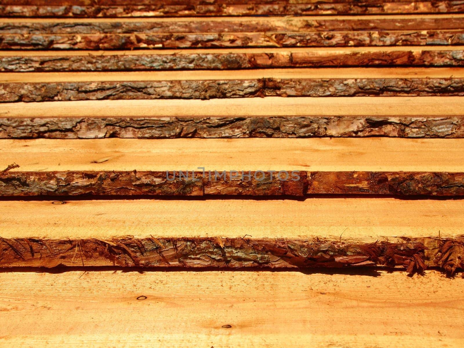 Rough wooden pine planks with bark on the side. It resembles a set of stairs.