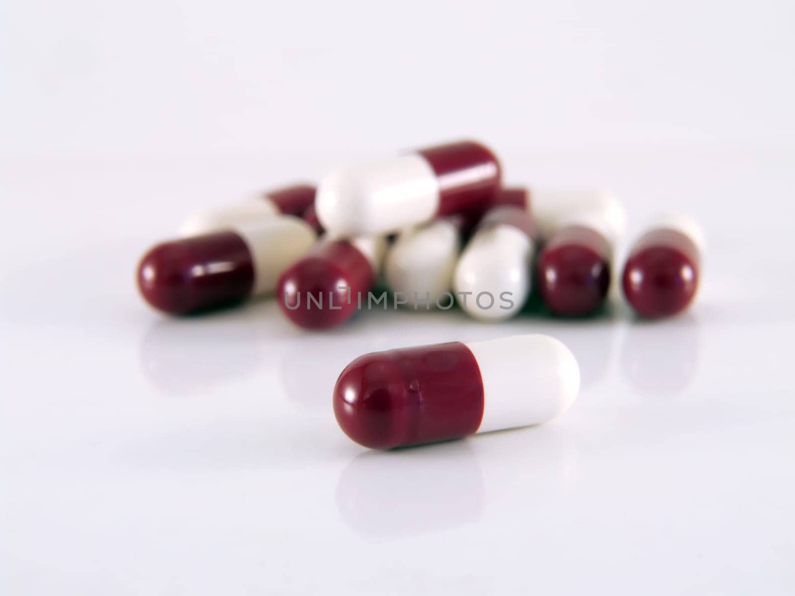 closeup red white pills over white background