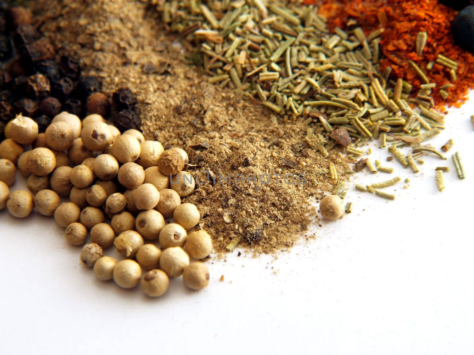 closeup of various colorful spices over white