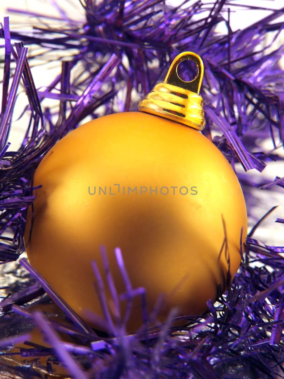 Golden christmas ornament in violet decorative ribbon