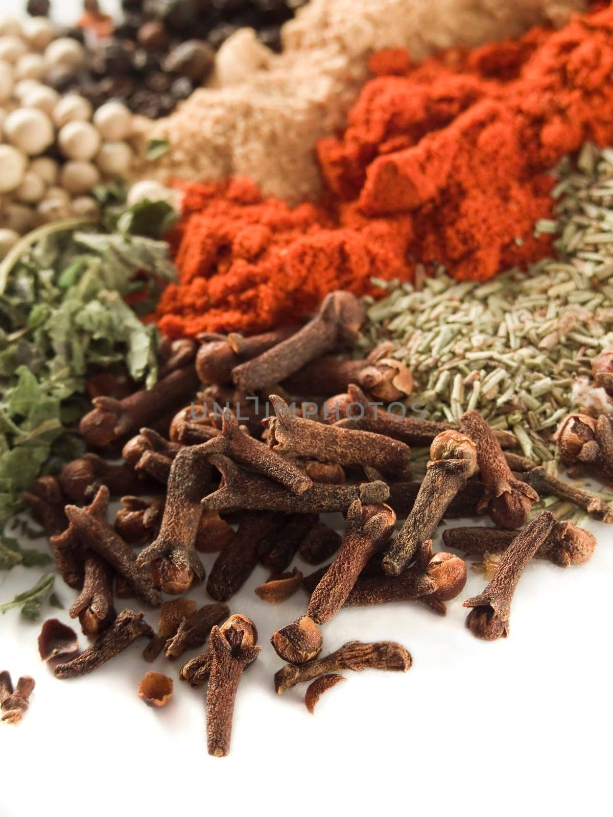 closeup of various spices over white