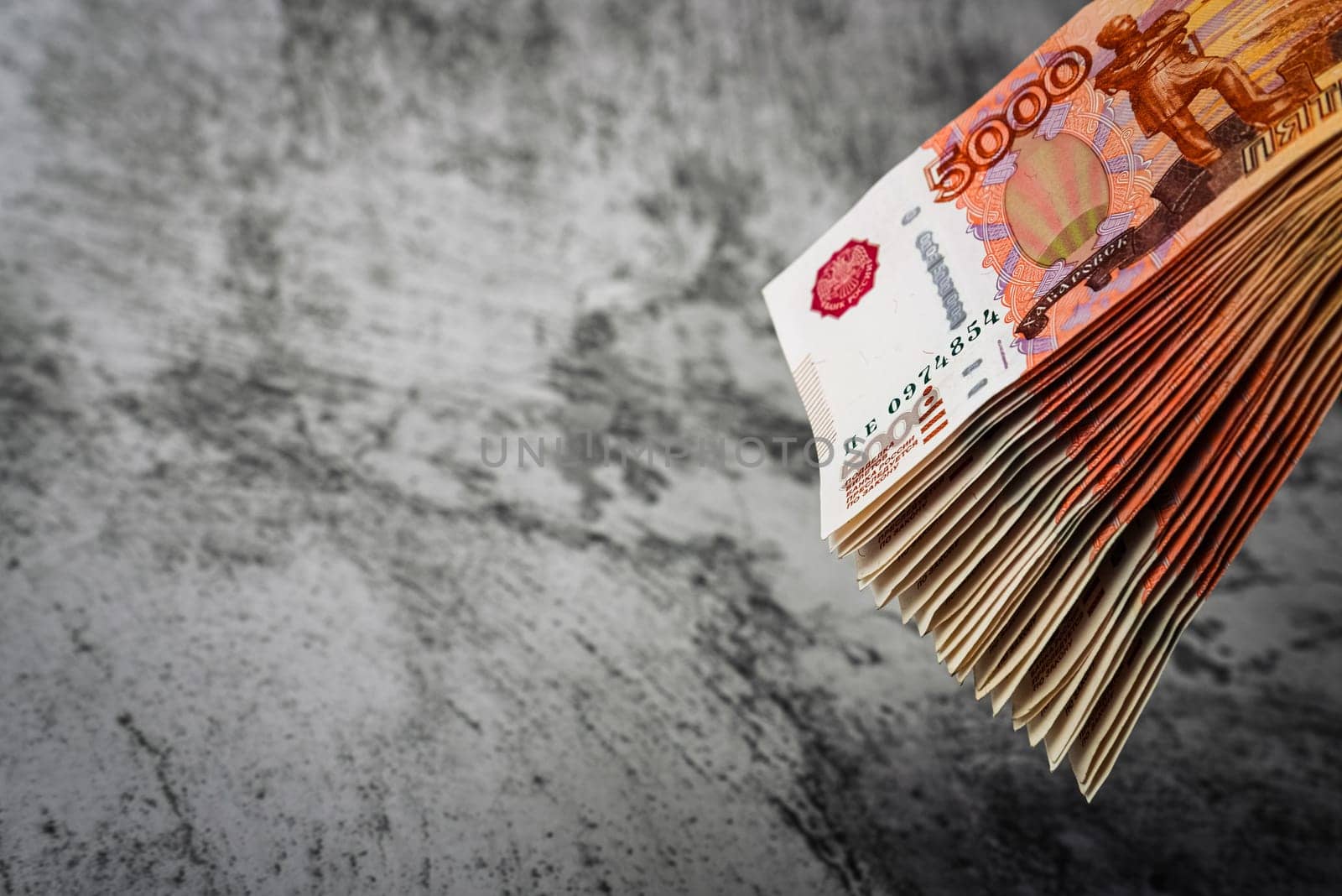 Russian rubles a large bundle on a gray background. A bundle of five-thousand-ruble notes. Place for logo, text, layout, mockup.